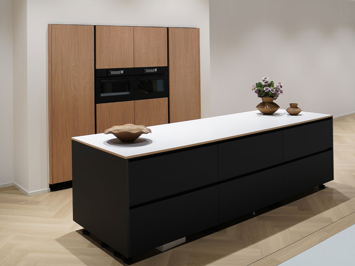 Moderne keuken met zwart kookeiland en houtlook kasten