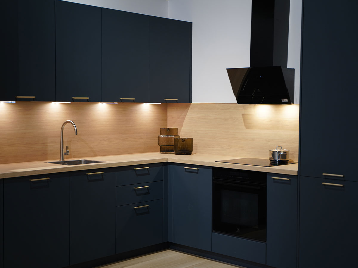 Donkerblauwe hoekkeuken met houtlook achterwand