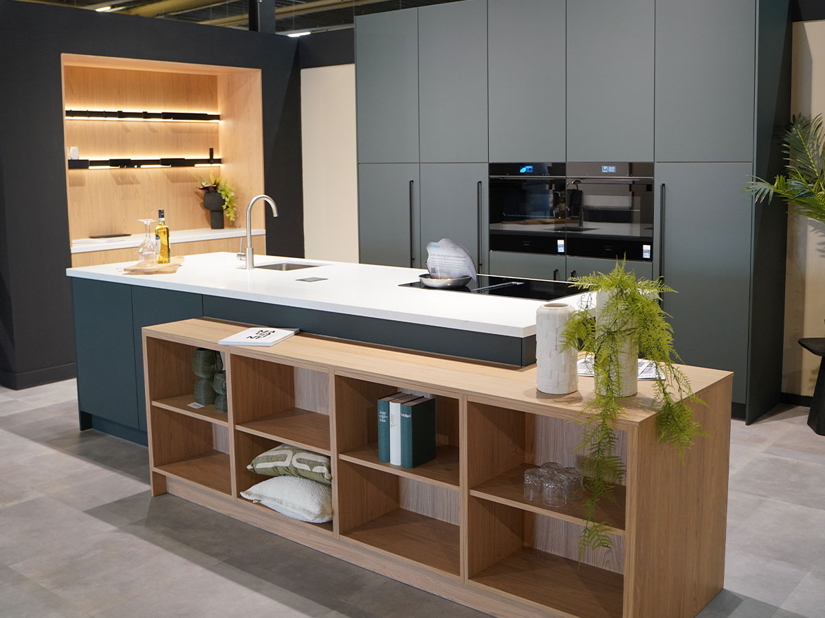 Moderne groene keuken met kookeiland in de showroom van Bouwhof